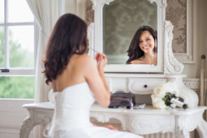 bride doing make up in mirror
